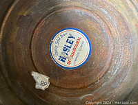 Bottom of brass planter showing original Hosley sticker and embossed markings