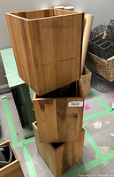 Three stacked wooden rectangular boxes with natural grain and warm brown color, used for storage or organizing.