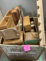 View of multiple wooden boxes stacked inside a large rolling box with an Atomic style faceplate on front.