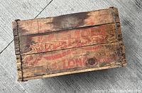 Top view of vintage wooden Pepsi Cola crate showing faded red branding and wood grain with metal corner reinforcements.