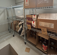 Two metal wire shelving units assembled with storage boxes and bags on shelves (contents not included).