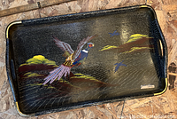 Wooden tray with painted pheasant, gold cloud and bird design, black background, metal corner protectors, and cut-out handles.