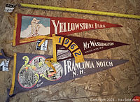Vintage 50s-60s Yellowstone, Mt Washington, Franconia Notch pennants arranged on wooden floor with measuring tape for scale.