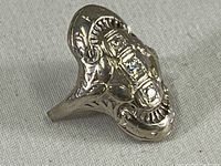 Angled front view of ring head showcasing engraving and three diamond accents