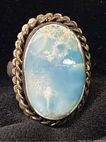 Front view of the sterling silver ring highlighting the light blue agate stone and twisted rope design bezel setting.