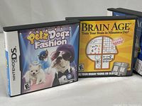 Front cover of two Nintendo DS games: Petz Dogz Fashion and Brain Age, showing artwork on cases.