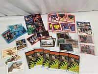 Overview of various loose and packaged vintage trading cards from multiple genres laid out on a surface.