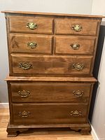 Front view showing tall dresser with seven drawers, bracket feet