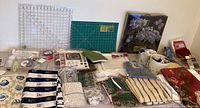 Wide view of the entire lot including cutting mats, fabrics, sewing box and additional supplies