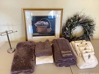 Overall view of bath towels, embroidered linen towels, decorative lavender wreath, and framed print.