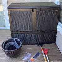 Front view of brown Suncast resin outdoor storage container with faux rattan texture, hinged top lid closed