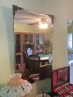 Full front view of vintage wall mirror reflecting room interior including cabinet and chairs, showing overall size and condition.