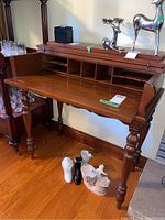 Wood secretary desk with lid open showing spacious writing surface and cubbyholes inside.
