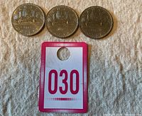 Three 1982 Canada Voyageur 1 Dollar coins arranged in a row above a card with '030' on it.