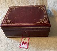 Jewelry box closed showing dark red exterior with gold decorative accents