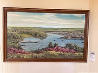 Full view of framed painting on wall showing waterfront landscape with boats and trees