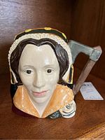 Front view of Royal Doulton Toby mug showing Catherine Howard’s face and detailed headdress.