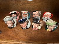 Front view of the eight Royal Doulton Toby character mugs and jugs on a wooden surface showing all characters together.