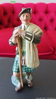 Front view of Royal Doulton 'The Laird' figurine showing facial details and front of the attire including kilt and shawl.