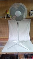Front view of the white 16 inch FOR LIVING oscillating fan showing the circular grille and pedestal stand.