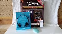 Full view of the guitar lesson kit items including the Complete Guitar book/DVD set, Logitech H151 USB headset in box, and wireless mouse on a wooden surface.