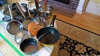 Overview showing all pots, strainers, and flour sifter arranged on table