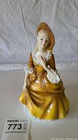 Front view of Royal Doulton figurine 'Sandra' showing detailed facial expression, dress, and hat.