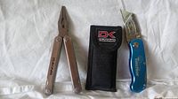 Photo showing Dakine multi-tool and Tomas cutter alongside black Dakine nylon sheath