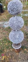 Photo shows one of two white-dusted triple spherical topiary plants about 3 feet tall, with dense synthetic foliage simulating frosted greenery.