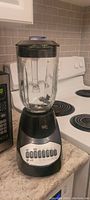 Photo of black and silver blender with glass jar and control buttons on kitchen counter
