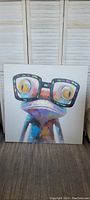 Front view of large mixed media frog painting with black square glasses, colorful vibrant style on white background.