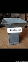 Side view of the metal planter showing its tapered square shape and height label of 14 inches.