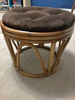 Side view of the rattan stool with a brown cushion on top (not included).