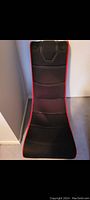 Front view of the black foldable rocking gamer chair showing padded seat, headrest speakers, and red trim