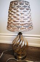 Full view of the wicker table lamp showing the entire lamp including base and lampshade.