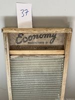 Front view of vintage wooden clothes washer with metal washboard and branding visible