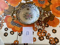 Overview of the Limoges bowl showing shape, handles, and floral decoration.