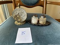 Wide view of coaster holder, glass coasters, salt and pepper shakers on tray sitting on a chair.
