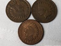 Obverse side of three USA Indian Head pennies dated 1901, 1906, and 1907 showing Lady Liberty with Native American headdress.