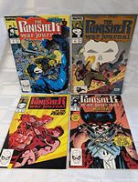 Four vintage 1980s Marvel comic books with Punisher and Wolverine covers laid flat showing front covers.