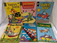 Photo showing full frontal view of six vintage comic books including Daffy Duck, Peter Pan, Super Goof, Bugs Bunny, Huey Dewey and Louie, and Chip 'N Dale with visible wear.