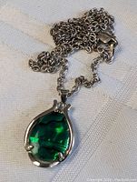 Close-up photo of the sterling silver chain with the green iridescent ammolite pendant.