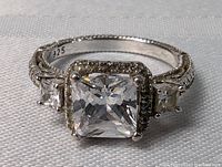 Clear view of the ring showing large square center crystal and side stones with 925 sterling silver marking inside the band.