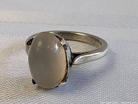 Side angle showing the oval moonstone set in a sterling silver band with smooth vintage styling.