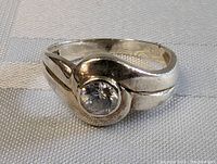 Clear view of the sterling silver ring with a bezel-set clear round quartz stone, showing band design and condition.