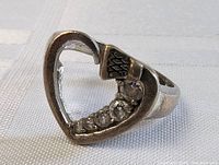 Close-up angle showing heart-shaped ring with six quartz stones along the bottom right inside the heart shape on a sterling silver band.