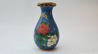 Front view showing full vase with blue enamel floral design