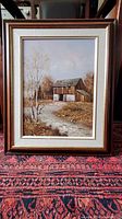 Full view of framed oil painting showing rustic barn landscape with autumn foliage, dirt path, and white birch tree in foreground.