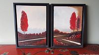 Pair of framed oil paintings showing red tree landscape scenes, placed side-by-side