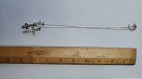 Full necklace with three cross pendants and ruler showing length.